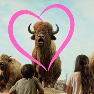 Two children staring up at one of the bison in the Manitoba Museum's iconic Welcome Gallery diorama. A pink heart has been superimposed in the image to frame the bison.