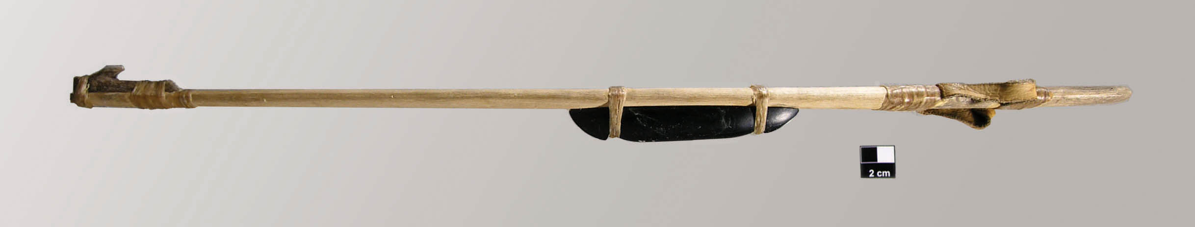 A long, thin shaft with a handle of leather straps on one end, and a point for a dart to attach for launching at the other end. A flattish stone is attached to the third of the shaft closest to the handle to serve as a counterweight.