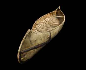 A canoe made of birch bark against a black background.