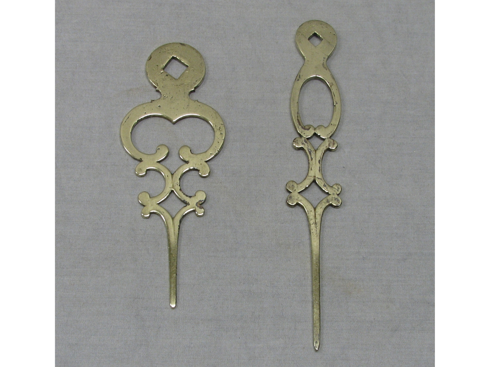 Two shiney brass clock hands (removed from the clock).