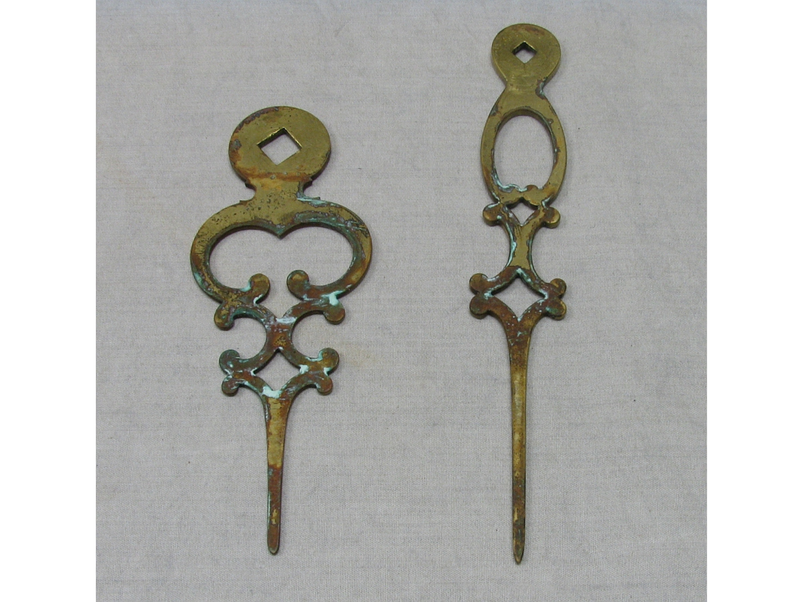 Two corroding brass clock hands (removed from the clock).