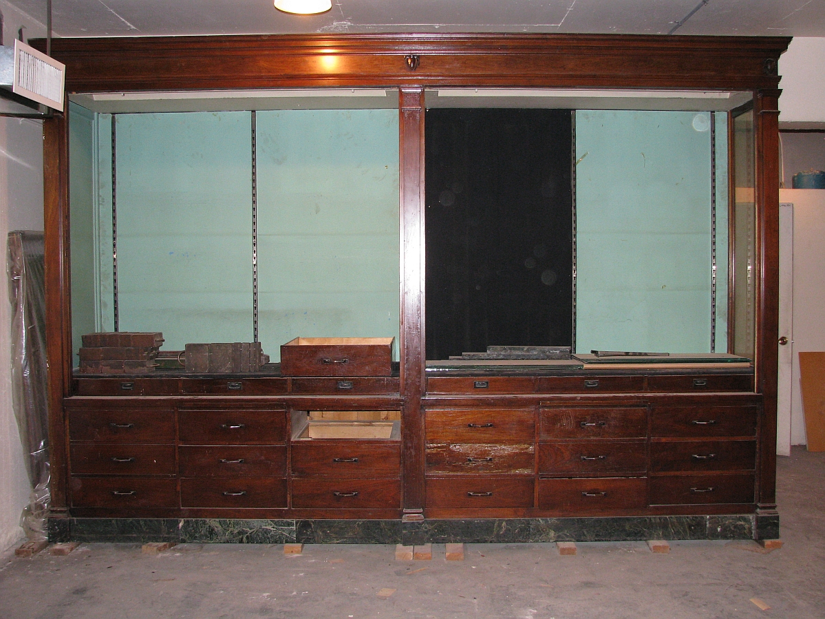 A large display case with drawers along the bottom portion and two large openings on the top.