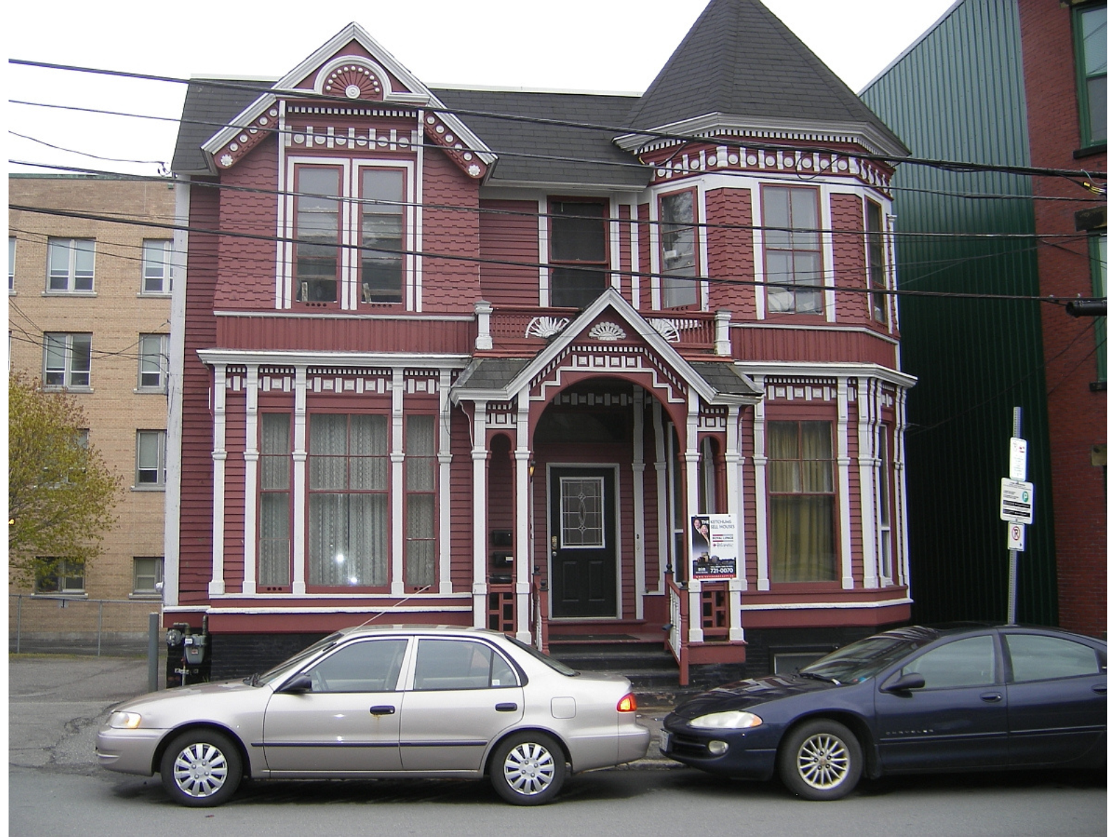 The exterior of a large red historic house with white trim.