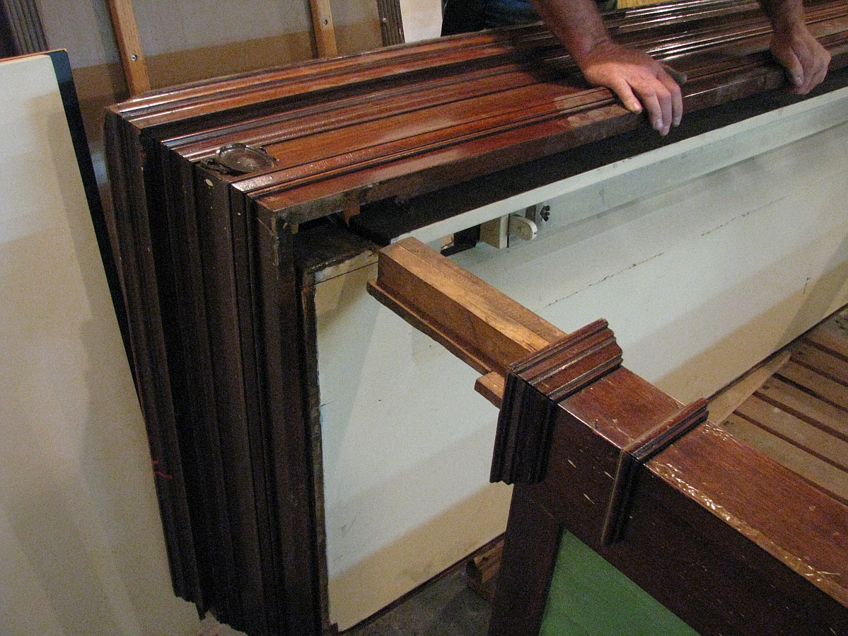 A large display case with its top being removed from the side posts.