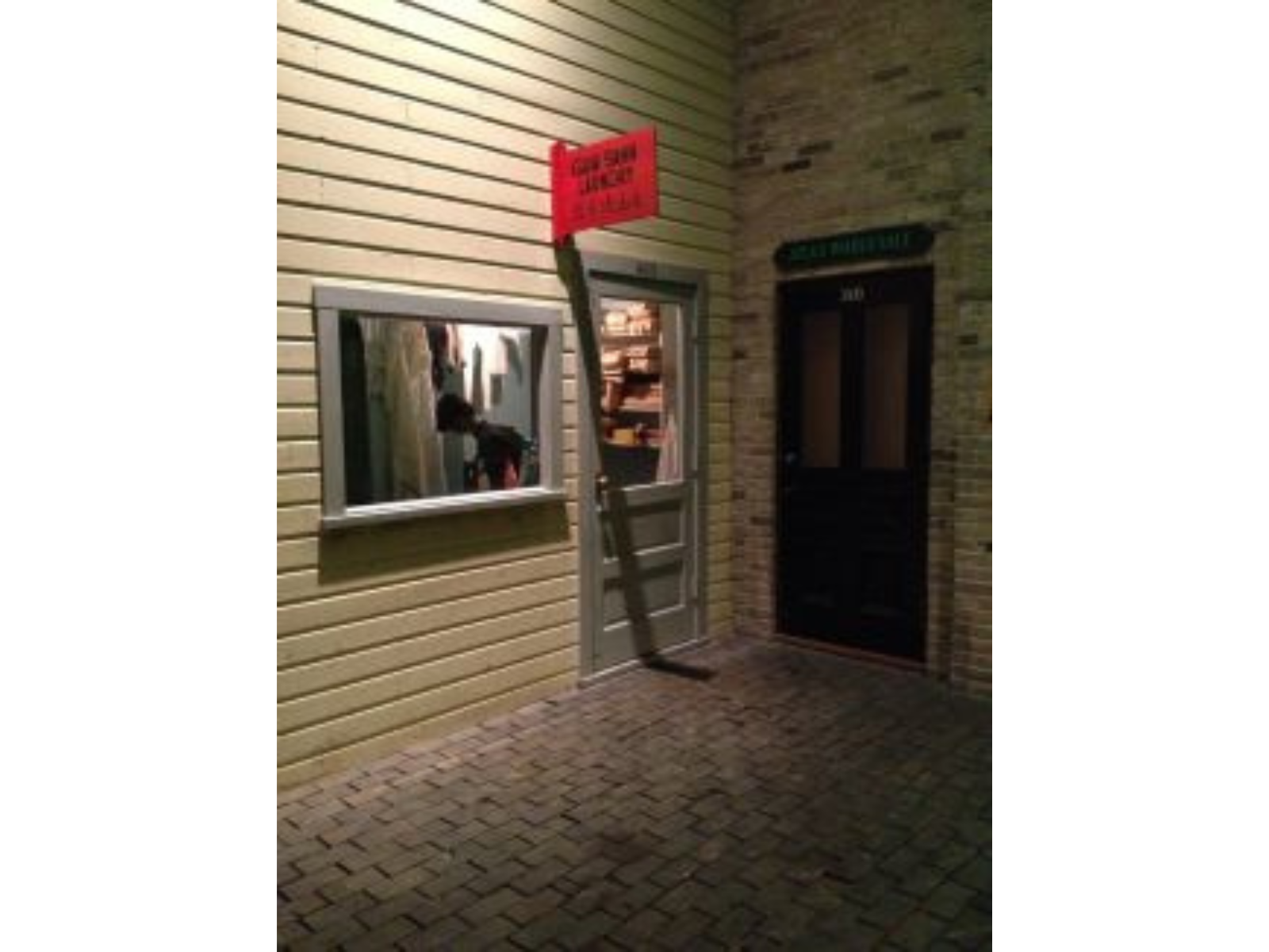 Storefront of a recreation of the Gum Sahn Laundry. Inside a mannequin is positioned to be working on the laundry.