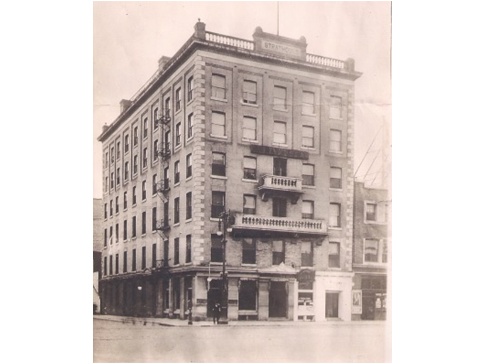 A sepia-toned photograph of a six-storey building with many windows.