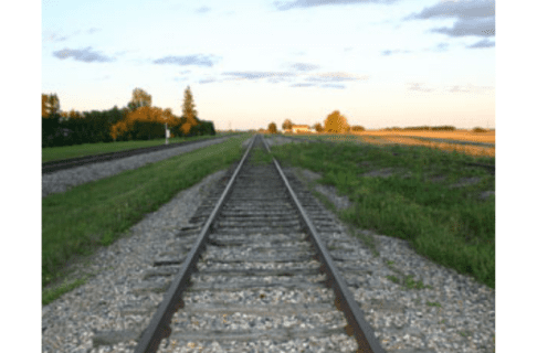 Looking down a railway track with grassy banks on either side.