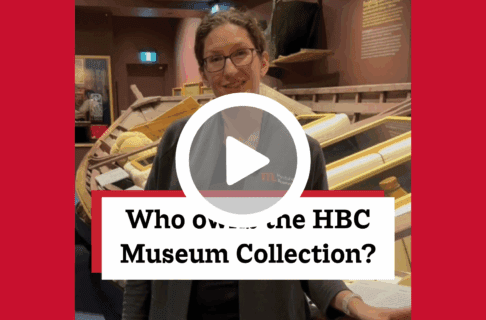 A screenshot of a video, an individual stands in the HBC Museum Collection Gallery next to a large York boat. There's a play button over the screenshot and overlaid text reads, "Who owns the HBC Museum Collection?".