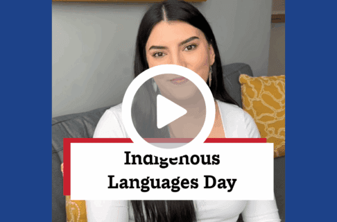 A screenshot of a video, an individual sits on a grey couch with yellow cushions. There's a play button over the screenshot and overlaid text reads, "Indigenous Languages Day".