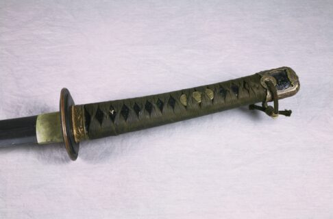 Close up on the hilt and handle of an old Japanese-style military sword.