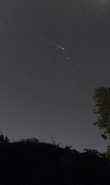 A meteor flashes overhead.