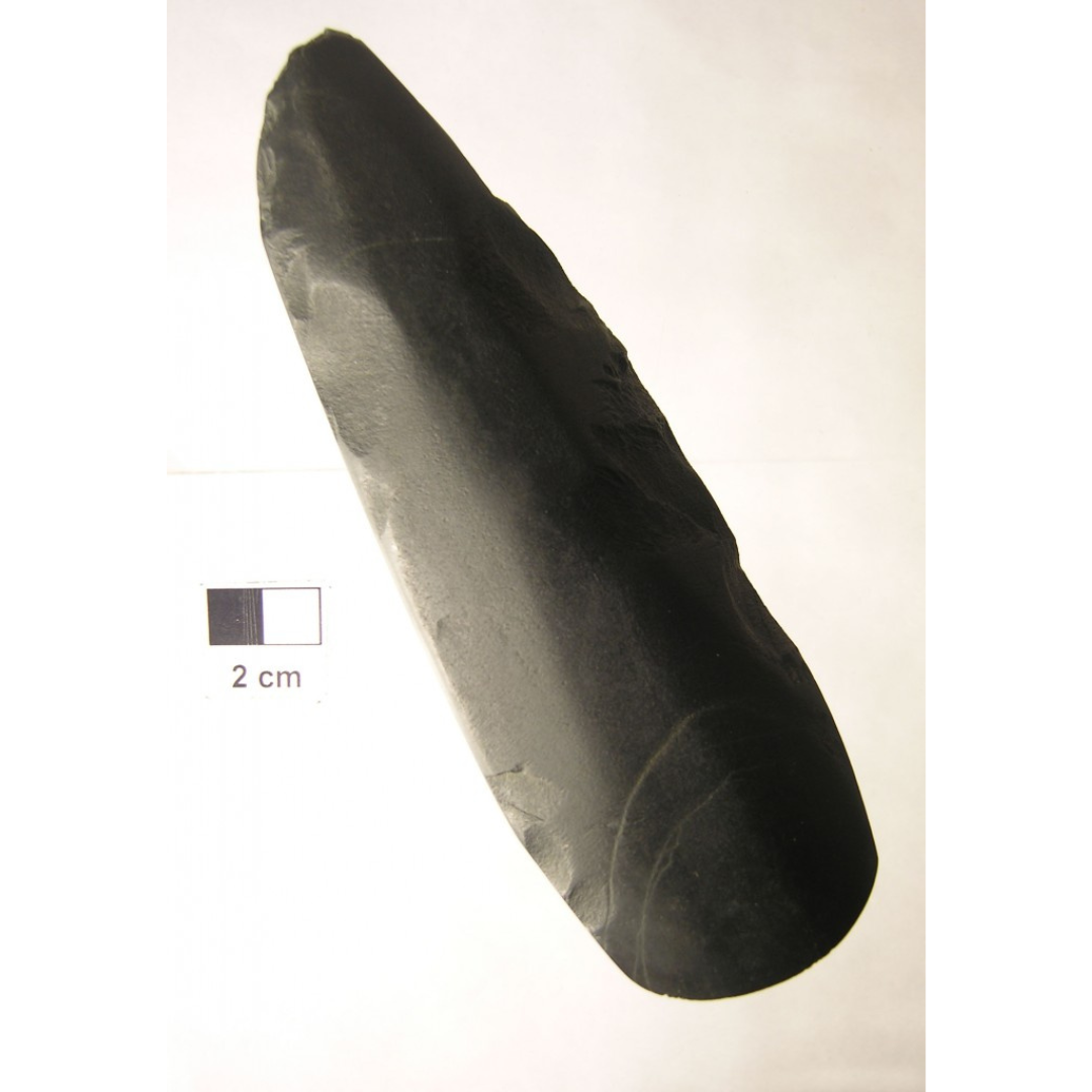 An oblong carved stone tool with sharpened edges.