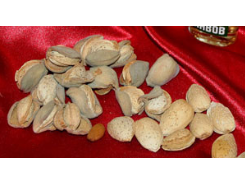 A small pile of almonds on a silky red fabric.