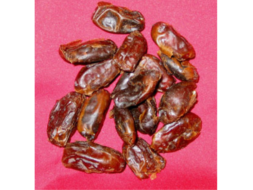 Small pile of dried dates on a red background.