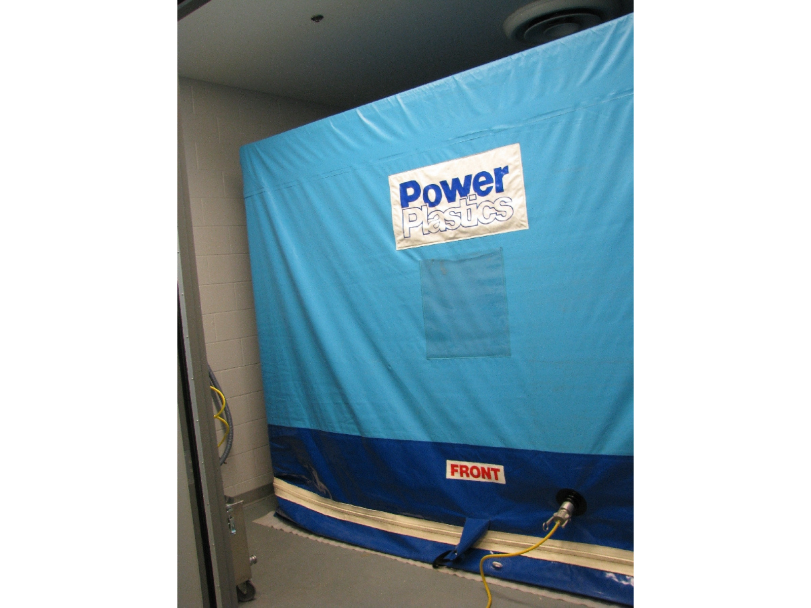 A rectangular shape covered with a bright blue tarp.