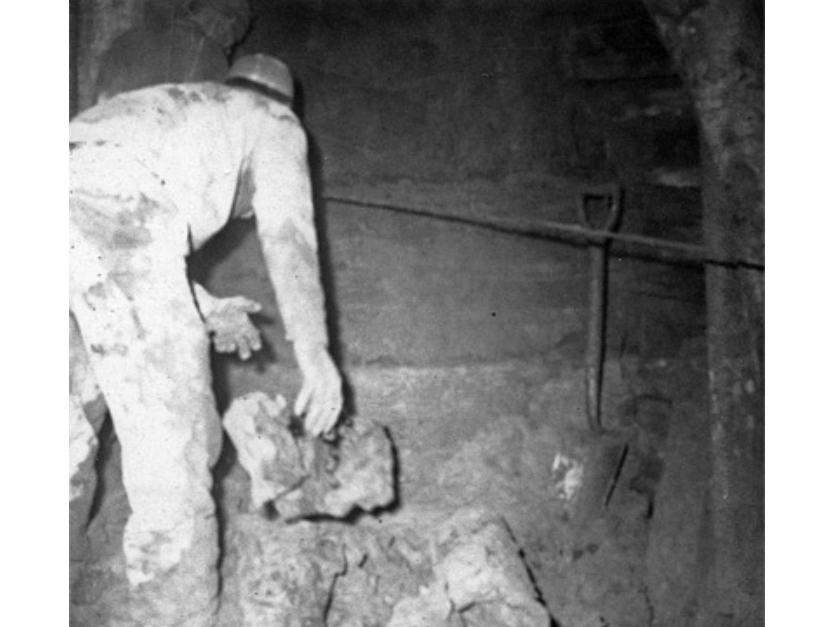 A black and white photograph of a construction worker in 1969 working on a sewer evacuation.