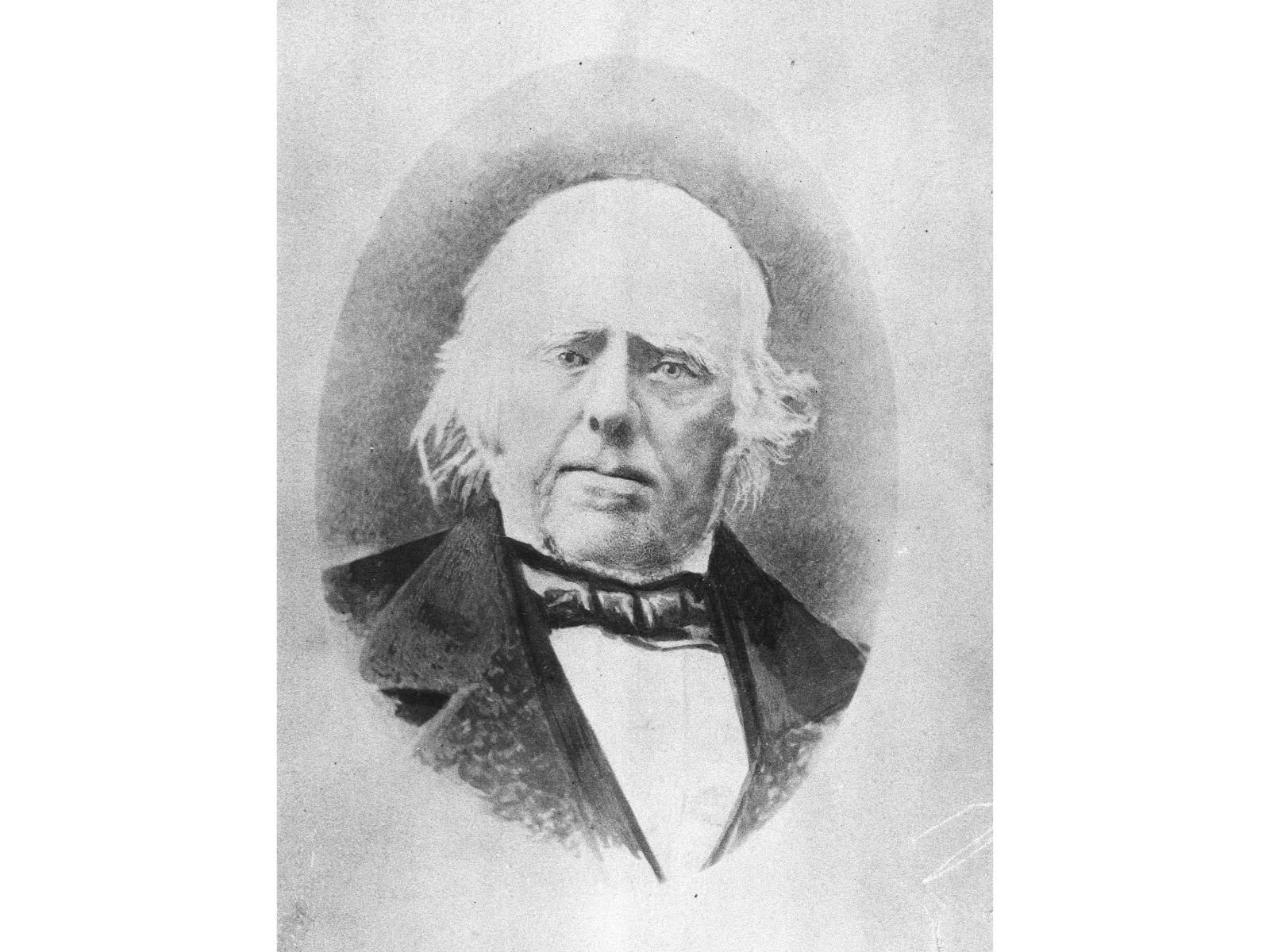 Black and white photograph of an older man wearing a bow tie over a white shirt with a dark suit jacket. His white hair sticks out a bit past his ears.
