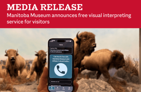 Photo of a hand holding a cellphone out in front of the iconic bison diorama in the Manitoba Museum Welcome Gallery. The phone screen is in focus with the Aira app open and text above a telephone symbol reading, "Call Aira for free with Manitoba Museum and Affiliate Cultural Institutions". Above, on a red background, text reads, "Media Release / Manitoba Museum announces free visual interpreting service for visitors".