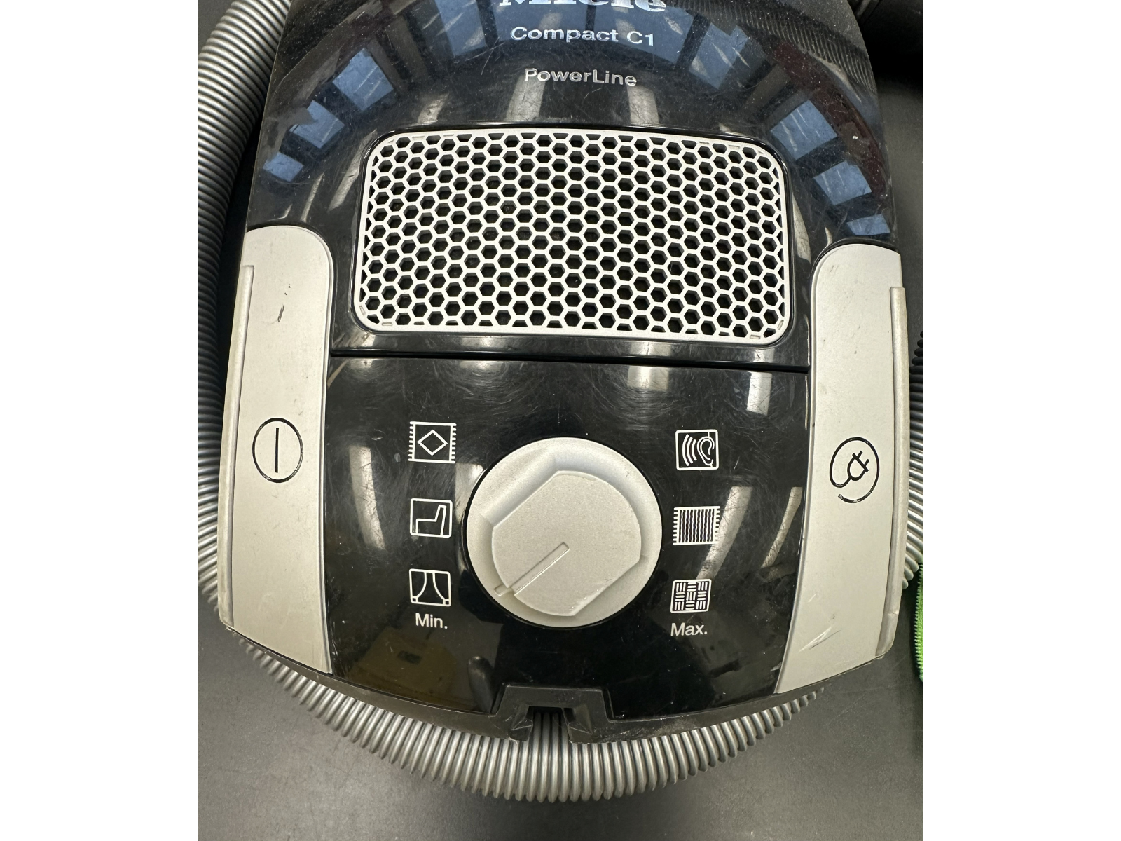 Close up on a canister vacuum control dial turned to the lowest setting of six.