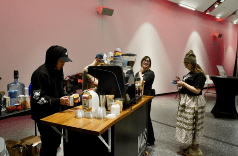 A pop-up coffee shop with a couple people lined up to order.