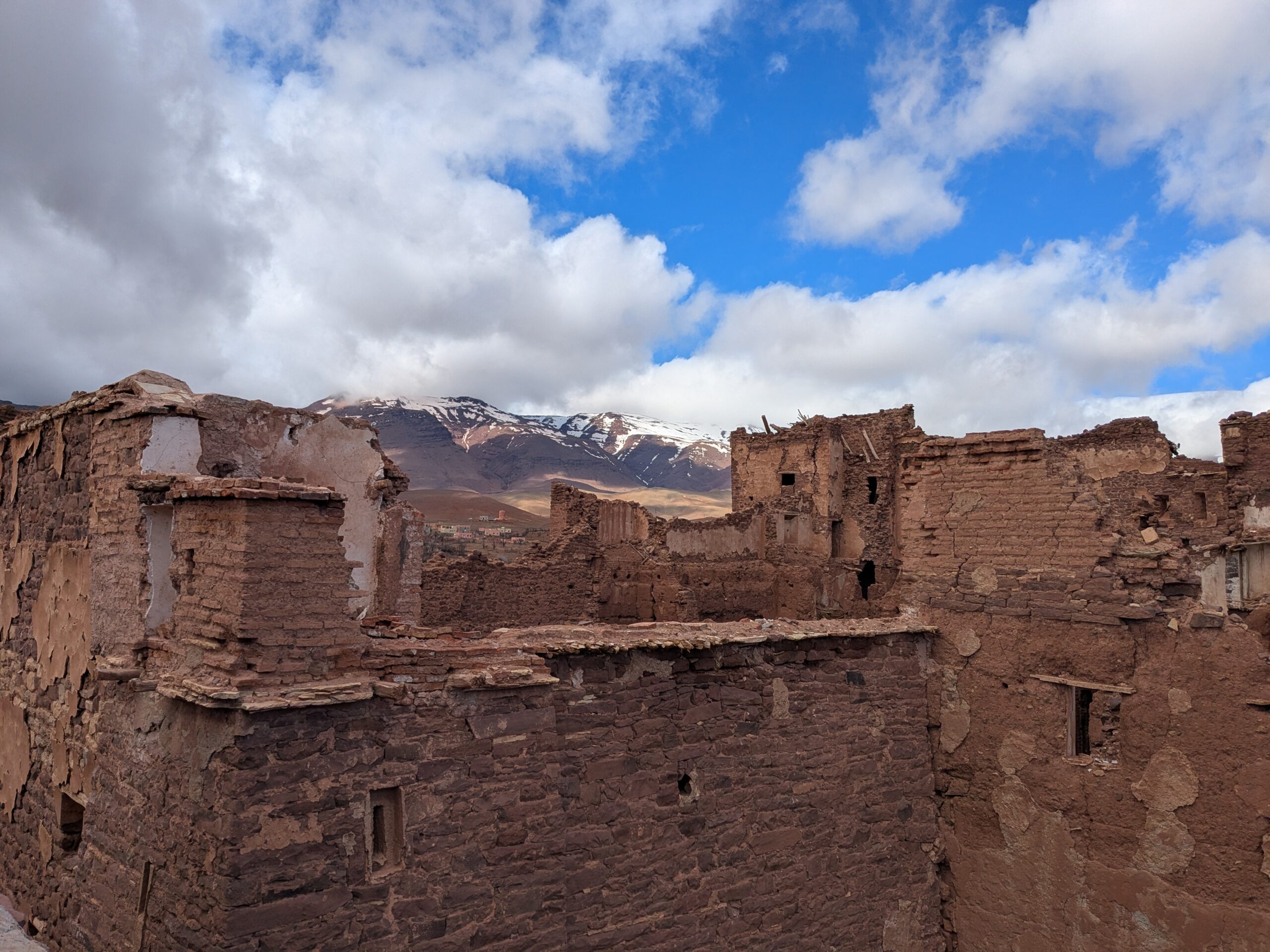 Looking out over the partial ruins of a large stone building, with distant mountains in the background.