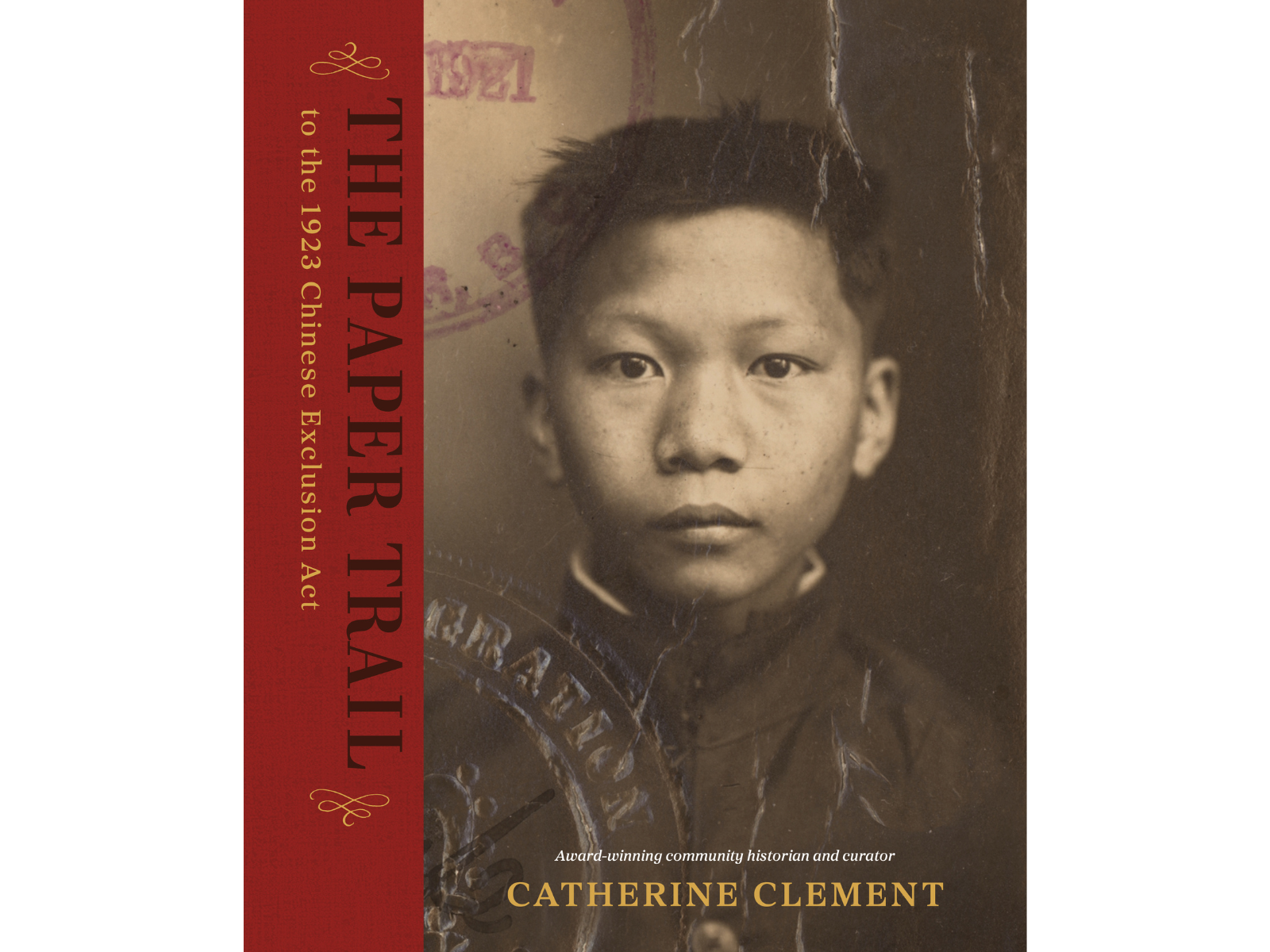 Book cover for The Paper Trail to the 1923 Chinese Exclusion Act. The cover features a historical identification photo of a young Chinese man, with the book title on a red bar along the left hand side. Author Catherine Clement's name is along the bottom.